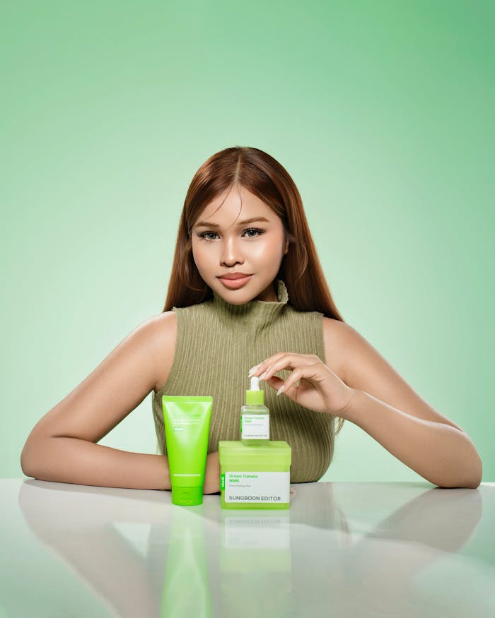 The Art of Drawing Readers In: Your attractive post title goes here A woman presenting green skincare products in a Phnom Penh studio with a soft green backdrop.
